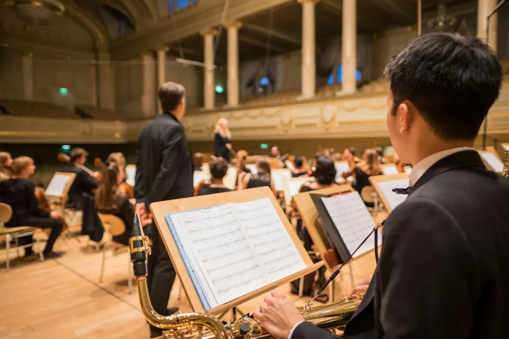 An over-the-shoulder shot looking into an orchestra where the musicians are warming up for a performance