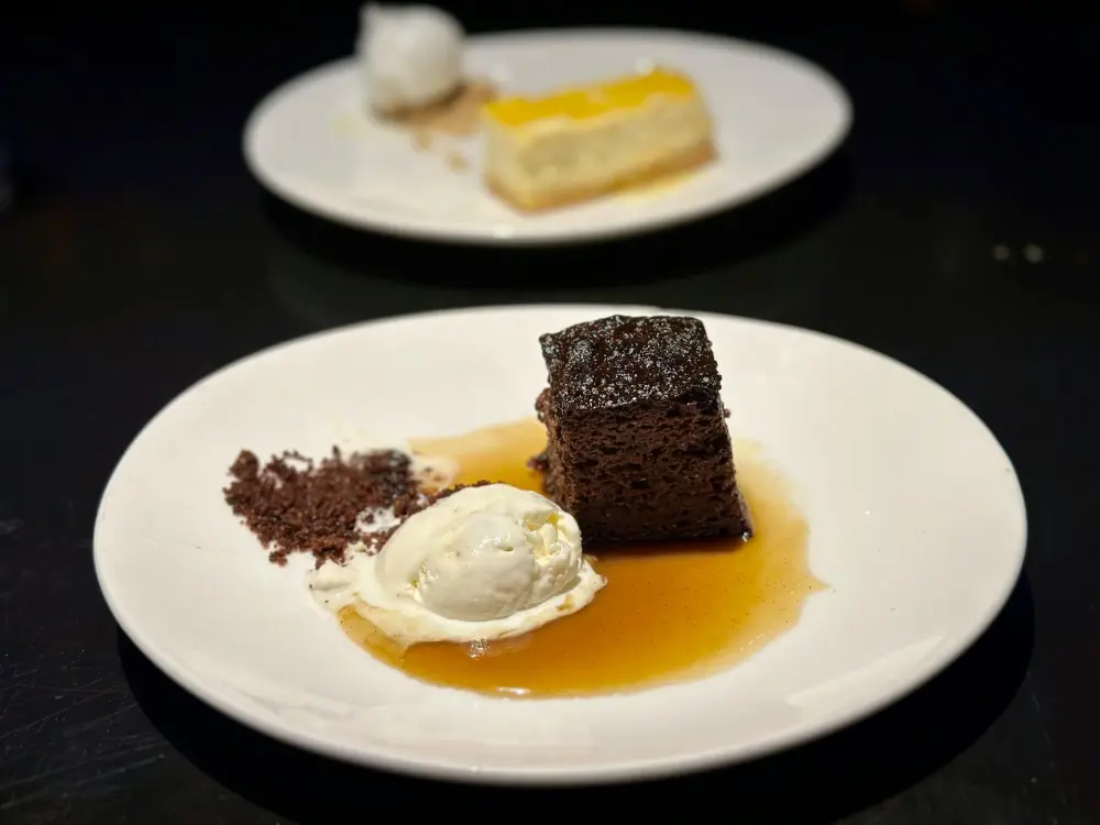 A close-up of a beautiful sticky toffee pudding with vanilla ice cream in one of Boston’s dining hotspots