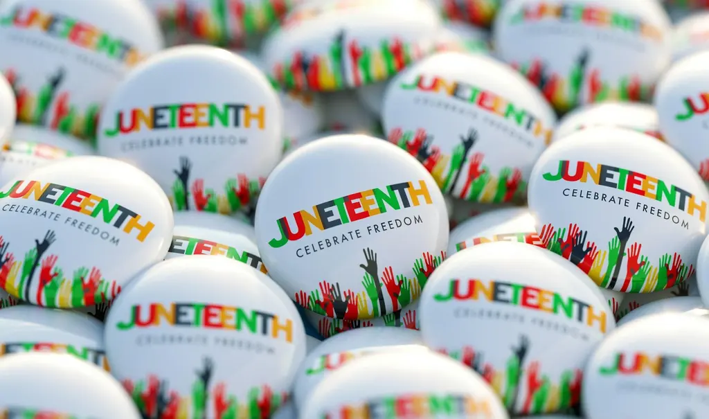 Juneteenth commemorative badges and pins arranged together, celebrating the federal holiday on June 19