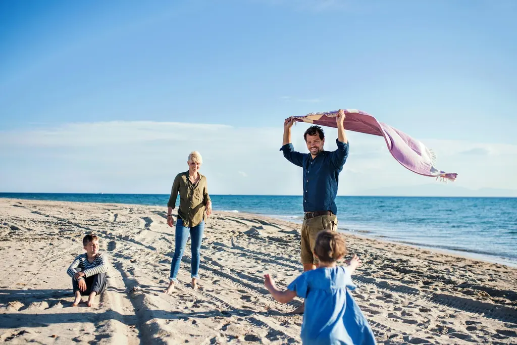 Family walking barefoot along a sandy Boston-area beach in early summer before the July crowds arrive