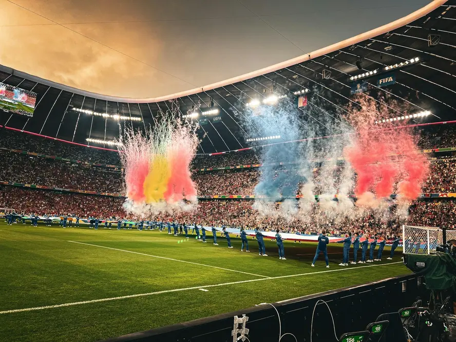 Pre-match pyrotechnics and flag ceremony inside a packed football stadium during a FIFA World Cup event