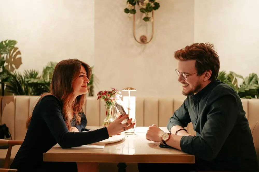 Couple enjoying dinner at a restaurant table with warm lighting